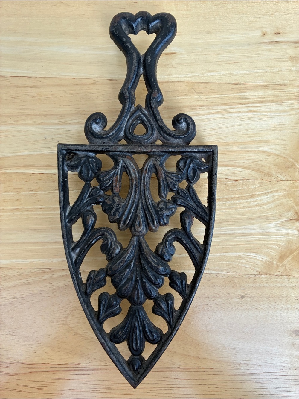 Ornate cast iron trivet.   Has wear.